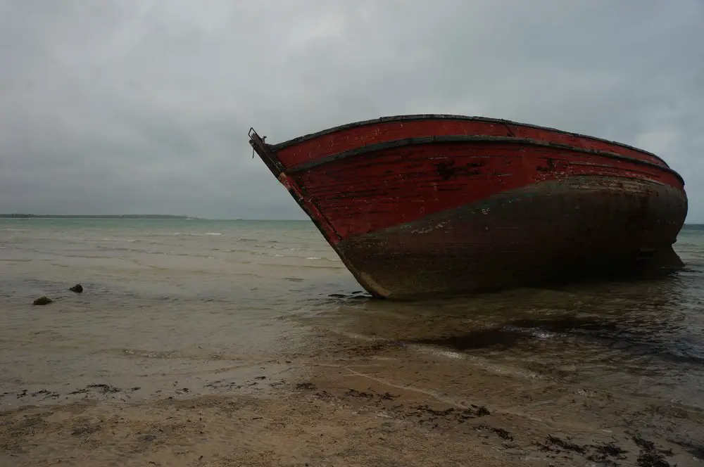 Lowtide boat resting on the beach in a cloudy day in Vilanculos.