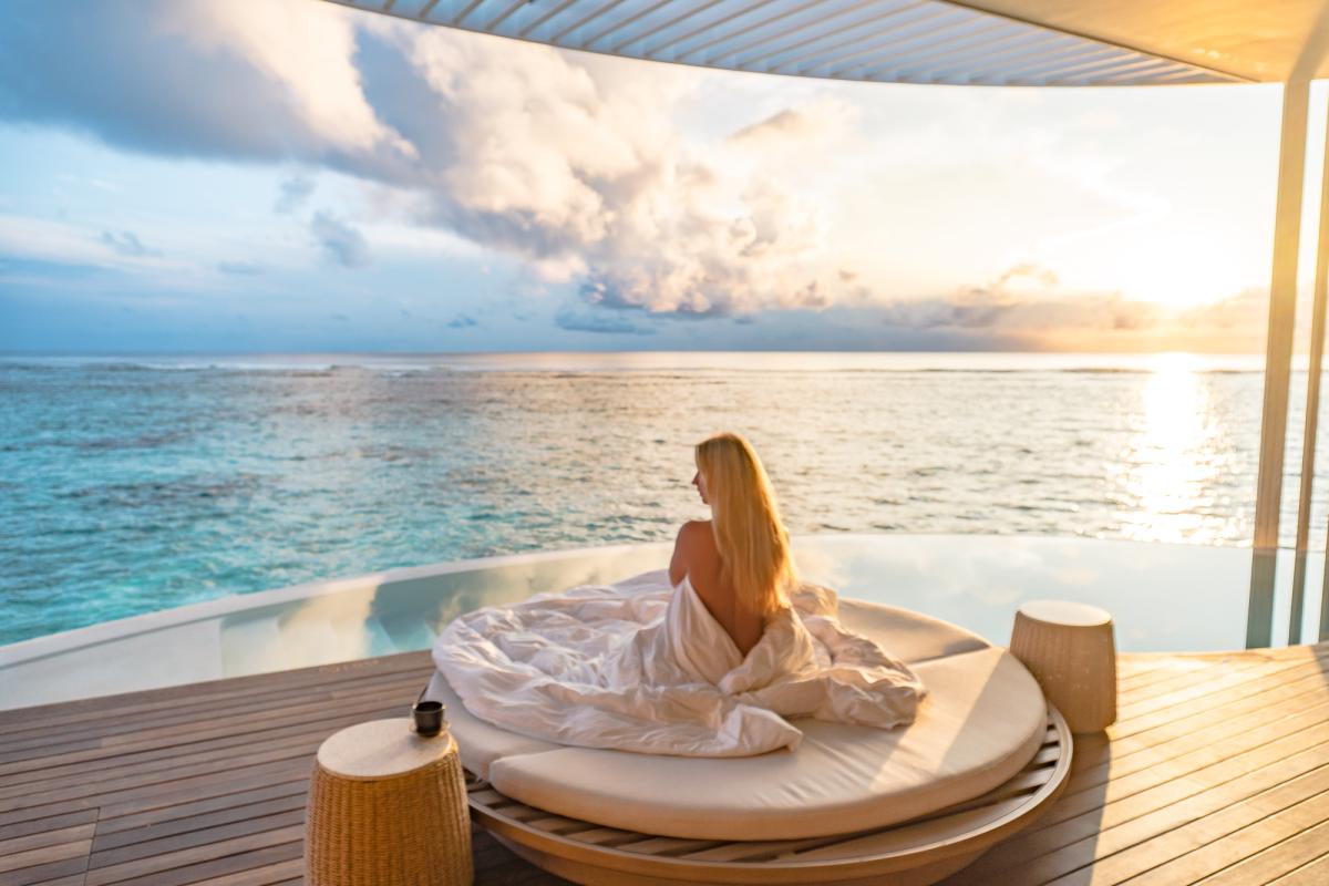 Drone shot ritz carlton maldives overwater villa sunrise
