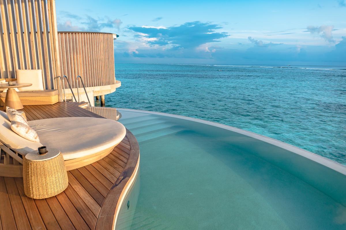Drone shot ritz carlton maldives overwater villa sunrise